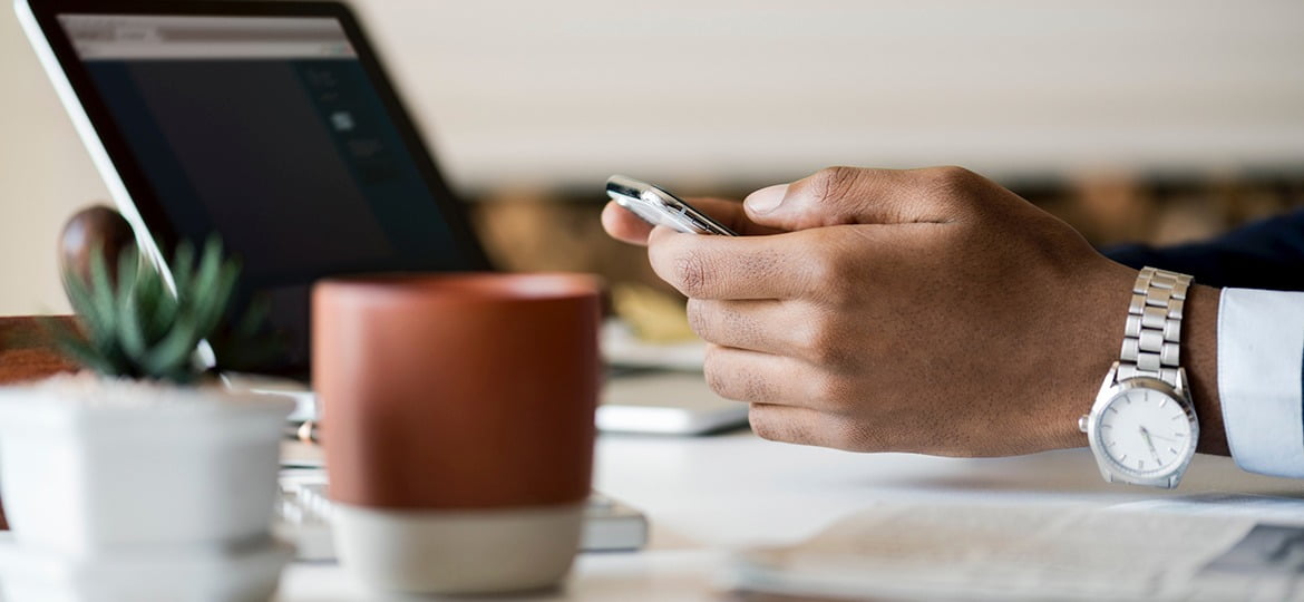 Homem de negócios usando smartphone em sua mesa de trabalho